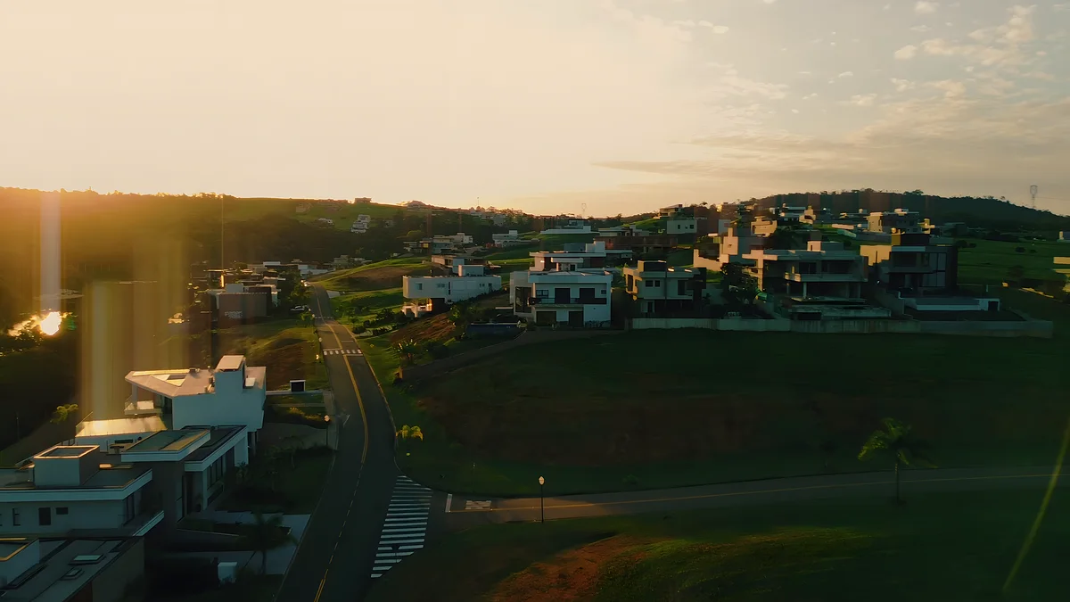 Casas do Fazenda Serra Azul ao pôr do sol, entre gramados e árvores