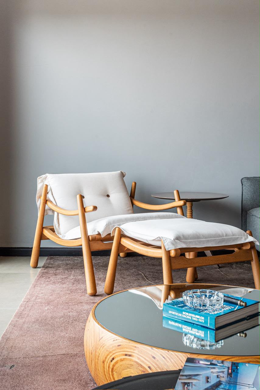 Detalhe de estar com poltrona de madeira e mesa de centro