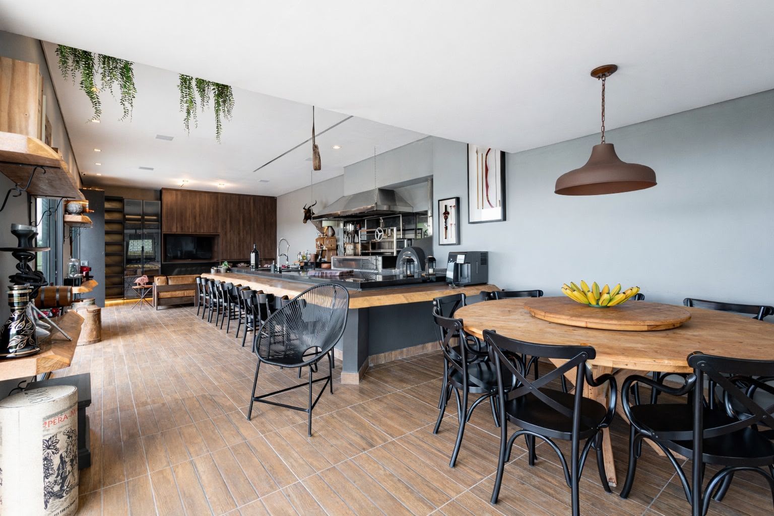 Área gourmet com mesa para grandes refeições e cozinha profissional
