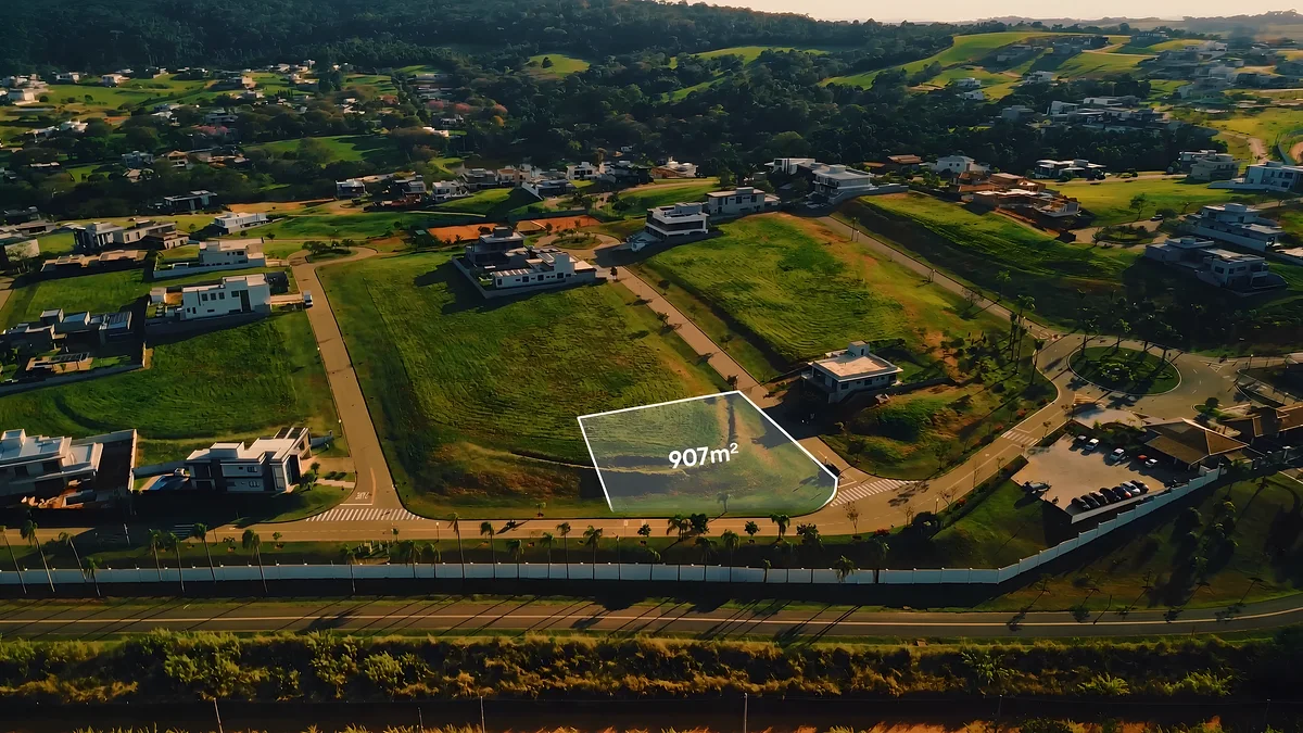 Vista aérea do lote de 907 m² demarcado dentro do condomínio, próximo à portaria